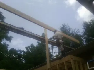 Carpenter setting a ridge beam over a new addition frame — Ice Dam Removal by Roofing Brothers in Jacksontown