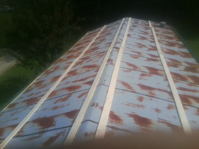 Rusted metal roof panels with new wood purlins before replacement — Storm Damage Roof Repair in Jacksontown by Roofing Brothers