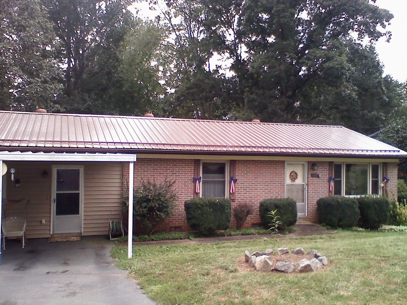 Bronze metal roof and carport on a brick ranch home — Roof Repair work by our crew in Jacksontown